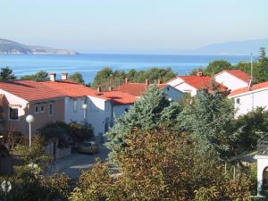 Une ville avec des maisons et l'océan en arrière-plan dans l'établissement Apartment Orbanić Cres, à Cres