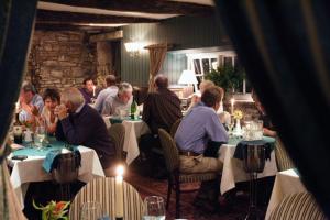 a group of people sitting at tables in a restaurant at Bear Crickhowell in Crickhowell
