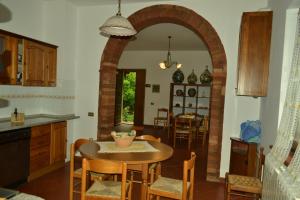 - une cuisine et une salle à manger avec une table et des chaises dans l'établissement Appartamenti La Miniera, à Castelnuovo Berardenga