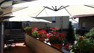 uma varanda com flores e guarda-sóis num edifício em Flying Hotel em San Maurizio Canavese