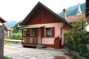 a small house with a window and a fence at Casetta Alex Desiree in Pontebba