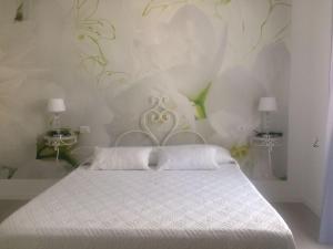 a bedroom with a white bed and two tables at Le Camere dei Fiori in Sanremo +86 photos