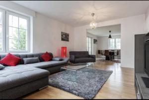 a living room with a couch and a table at Charmant appartement avec terrasse dans villa in Strasbourg