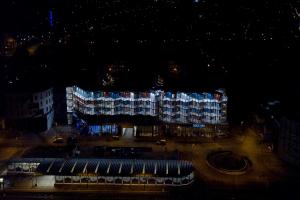 ein großes Gebäude mit beleuchteter Fassade in der Nacht in der Unterkunft DOCK INN Hostel Warnemünde in Warnemünde