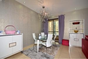 Murjan Suites Waterfront The Walk Jumeirah Beach Residence في دبي: غرفة طعام مع طاولة وكراسي بيضاء