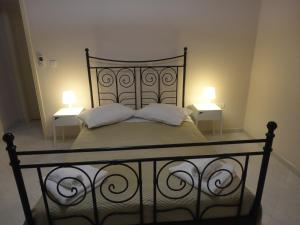 a bed with two white pillows and two tables at Yialos apartments in Kefallonia
