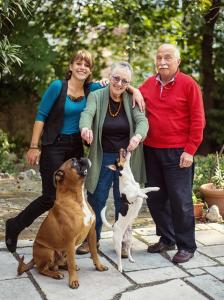 un gruppo di tre persone in piedi accanto a un cane di Villa Fausta B&B a Trieste
