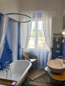 a blue bathroom with a tub and a sink at Can Sanllehí in Castelló d'Empúries