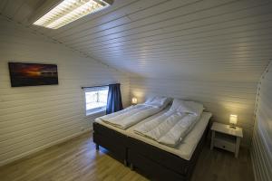 a bedroom with a bed in a room with a window at Malangen Apartment in Kjerkevik