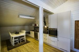 a kitchen with a table and a stove and cabinets at Malangen Apartment in Kjerkevik