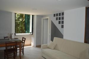 salon z białą kanapą i stołem w obiekcie Petros Room Camere w mieście Salerno