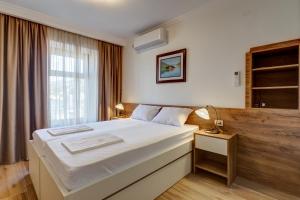 um quarto com uma cama grande e uma janela em Apartments Langust em Sveti Stefan