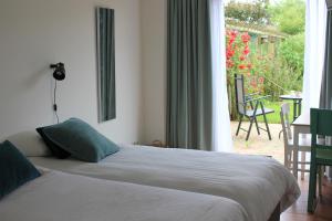 a bedroom with two beds and a view of a patio at Bluesheep-texel in De Koog