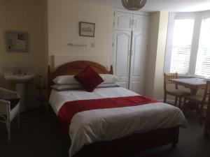 um quarto com uma cama grande e um cobertor vermelho em Bay Lodge em Aylesbury