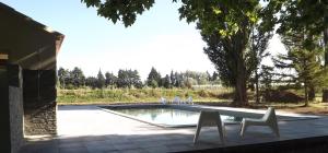 un patio avec deux chaises et une piscine dans l'établissement Lou Jas d'Aimé, à Cavaillon