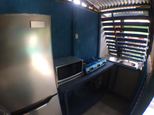 a small kitchen with a sink and a refrigerator at Green Macaw Hostel in Tortuguero