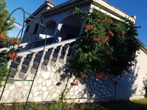un bâtiment avec un escalier fleuri dans l'établissement Maslina Apartment, à Jadrtovac