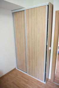 a sliding glass door in a room with a wooden floor at Leader apartment in Sarajevo