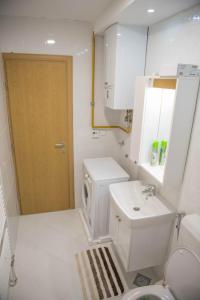 uma casa de banho branca com um WC e um lavatório em Leader apartment em Saraievo