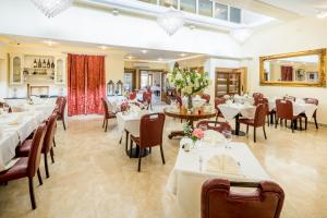 Linton Hotel Luton في لوتون: غرفة طعام مع طاولات وكراسي بيضاء
