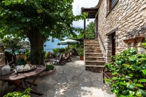 Un patio con una mesa y sillas y un árbol. en Villa Evdora, en Alyki