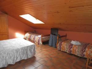 1 Schlafzimmer mit 2 Betten und einem TV in einem Zimmer in der Unterkunft Hostal El Portalico in Linares de Mora
