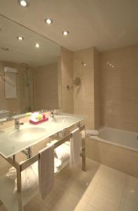 a bathroom with a sink and a tub and a mirror at Zenit Borrell in Barcelona