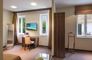 a living room with a desk and a bed and windows at Central Luxury Rooms in Omiš +37 photos