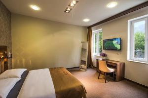 a bedroom with a bed and a desk and a television at Central Luxury Rooms in Omiš
