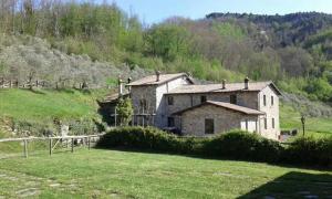 una casa su una collina con un campo verde di Le Chianine dei Tognoli a Gragnola