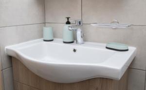 a white sink with two cups and a faucet at House for Relaxing Vacations in Keramoti +14 photos