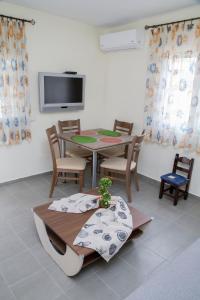 a dining room with a table and chairs and a tv at House for Relaxing Vacations in Keramoti