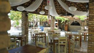 un ristorante vuoto con tavoli e sedie in legno di Spiti Nikos a Danilia