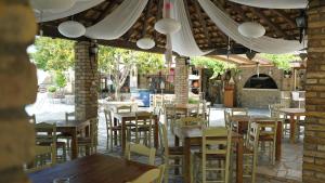 an empty restaurant with wooden tables and chairs at Spiti Nikos in Danilia