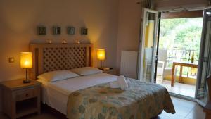 a bedroom with a bed with two lamps and a balcony at Spiti Nikos in Danilia +46 photos