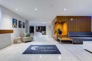 a lobby with a couch and chairs and a table at Aspect Caloundra in Caloundra