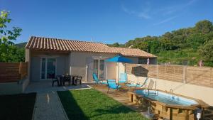 een huis met een zwembad en een tafel en stoelen bij LES LAUZES DE ST MICHEL-LA SARRIETTE in Entrechaux
