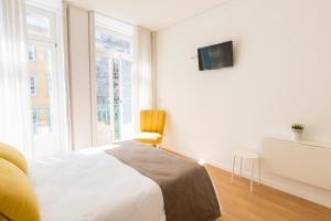 a bedroom with a bed and a tv on a wall at Downtown Porto Mouzinho Studio Apts in Porto
