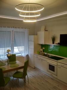 a kitchen with a table and a dining room at Anna Apartmanok in Pécs