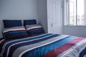 a bed with a colorful striped comforter in a room at 722 at 66 Keerom Street in Cape Town