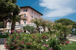 a pink building with palm trees and flowers at Oasis of Peace and Relaxation near Opatija in Matulji