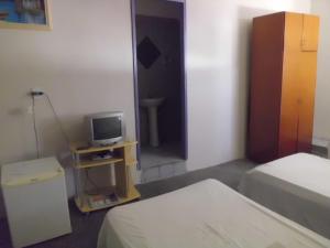 a bedroom with a bed and a tv on a table at Masuka Center Hotel in Petrolina