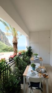 马卡里La Via dell'Acqua的一间设有桌子和棕榈树的用餐室