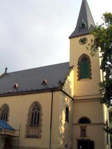 ポジェブラディにあるPenzion Čokoládaの緑窓時計塔のある教会