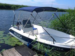 a boat sitting on the water next to a dock at Nad Krolewiecka in Sztutowo +46 photos