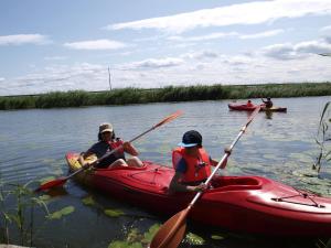 two people in kayaks on a river in the water at Nad Krolewiecka in Sztutowo