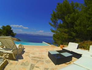a patio with a couch and chairs and a pool at Holiday house Karla in Vela Luka