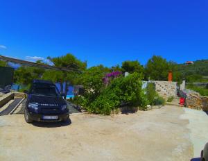 a car parked in a driveway next to a building at Holiday house Karla in Vela Luka