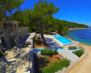 a house with a swimming pool next to the ocean at Holiday house Karla in Vela Luka