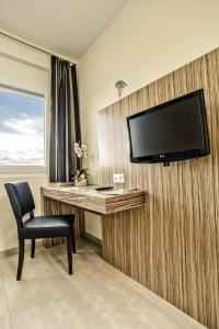Zimmer mit einem Schreibtisch und einem TV an der Wand in der Unterkunft Hotel Maxis in Karlsbad